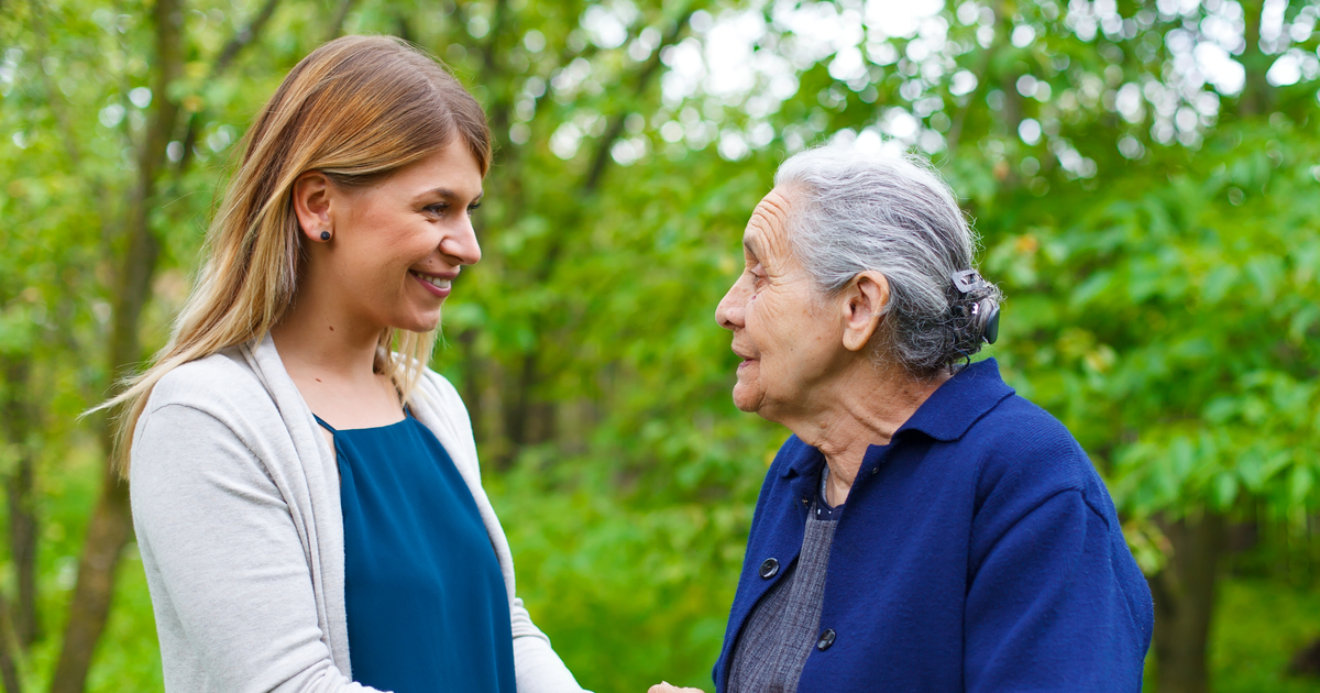 Senior woman outside with caregiver